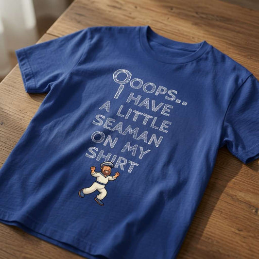 Blue Ooops.. I Have a Little Seaman on My Shirt t-shirt laid flat on a wooden surface showing the full text and mini sailor graphic, rude mens offensive sailor slogan