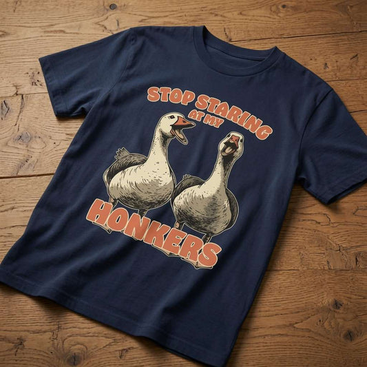 Navy Stop Staring at My Honkers t-shirt laid flat on a wooden surface showing the full pair of geese, funny and cheeky ladies animal graphic that every no-nonsense lady will claim