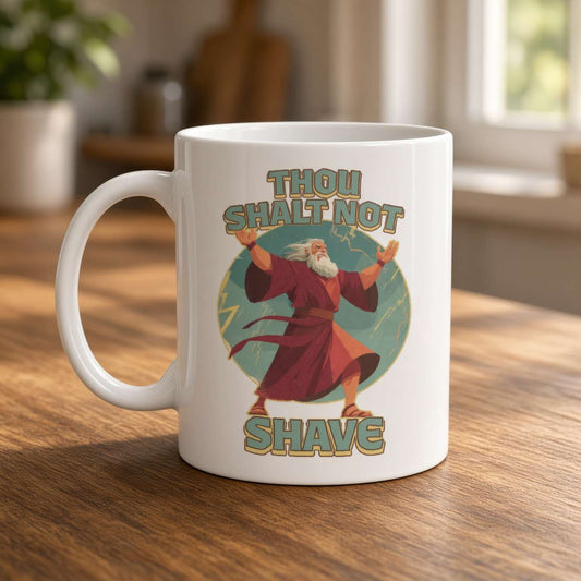 A white mug on a sunlit wooden table features a cartoon wizard and the playful slogan “Thou shalt not shave,” creating a warm, humorous feel.