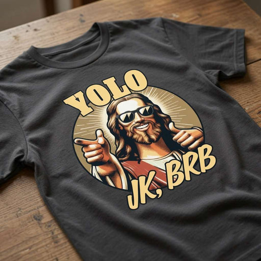 Black YOLO JK, BRB t-shirt laid flat on a wooden surface showing the full cool Jesus graphic, funny offensive witty mens Jesus graphic design full of pure attitude