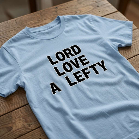 Light blue Lord Love a Lefty t-shirt on wood, funny mens memorable tv slogan