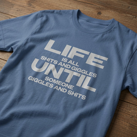 Blue Life Is All Shits And Giggles Until Someone Giggles And Shits t-shirt laid flat on a wooden surface showing the full slogan, cheeky mens witty age relatable slogan design full of pure attitude