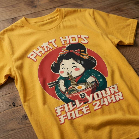 Yellow Phat Ho’s t-shirt laid flat on a wooden surface featuring a cartoon geisha slurping noodles with the slogan “Fill Your Face 24HR”, funny and cheeky mens takeaway pun graphic