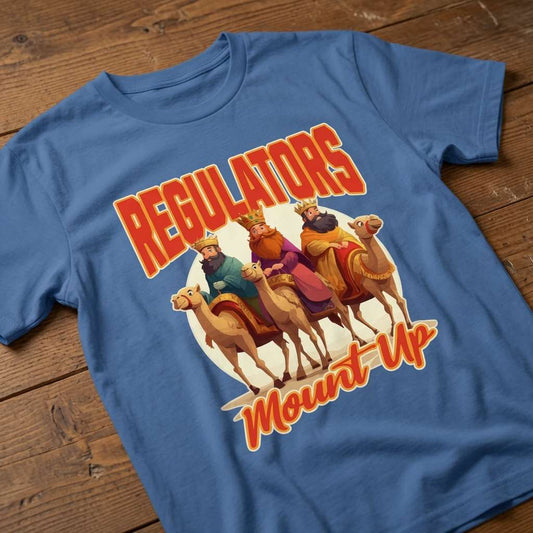 Blue Regulators Mount Up t-shirt laid flat on a wooden surface featuring the three wise kings riding camels, witty mens Christmas wise kings banter design