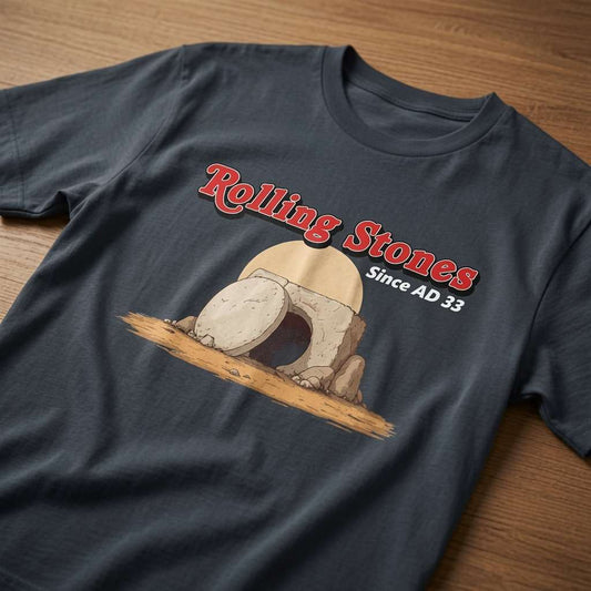 Ink grey Rolling Stones Since AD 33 t-shirt laid flat on a wooden surface showing the full empty tomb graphic, hilarious mens offensive jesus graphic design full of pure attitude
