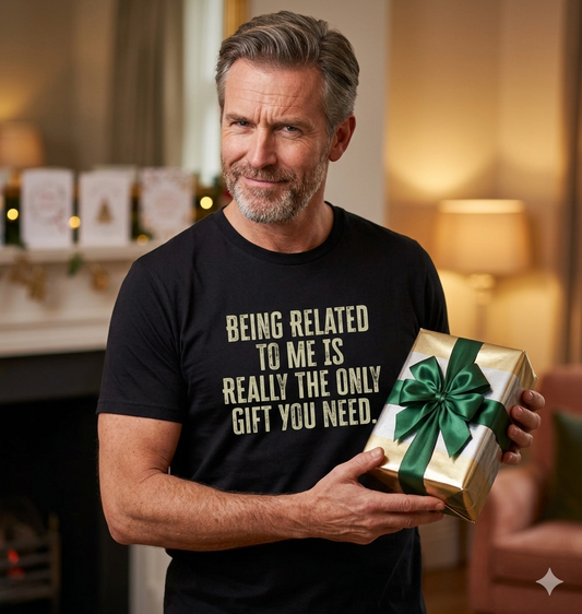 man holding a gift wearing a slogan t-shirt with the text 'being related to me is really the only gift you need'