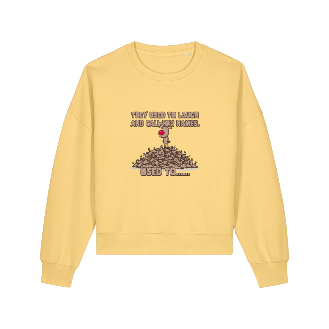 yellow christmas sweater with the graphic of rudoph stood ontop of a pile of reindeer and the slogan 'they used to laugh and call him names used to ..'