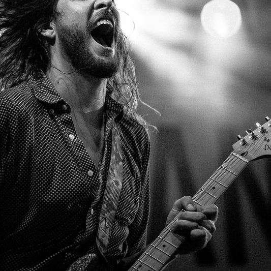 black and white image of a man playing a guitar