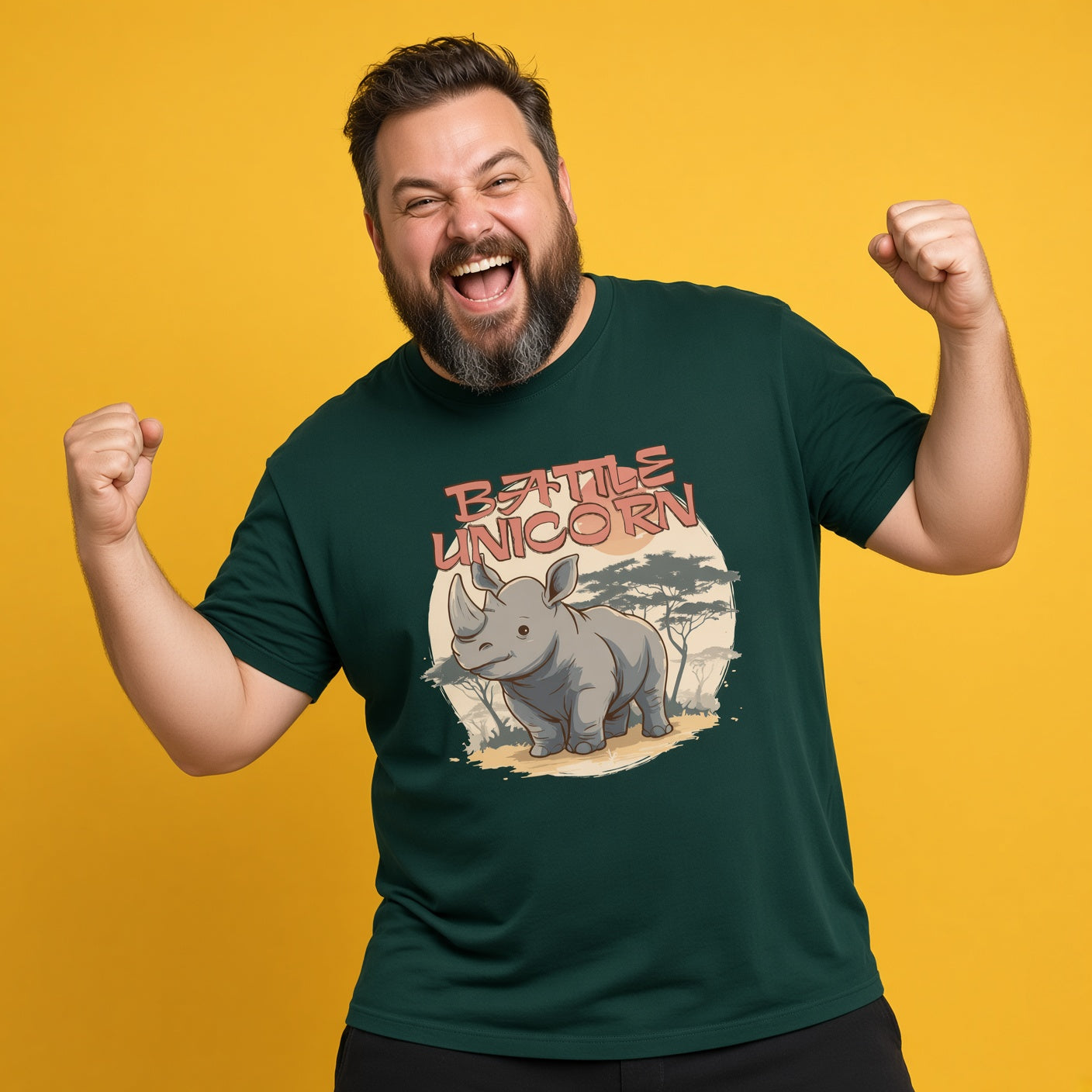 A smiling, bearded man raised his fists in excitement against a yellow background, wearing a dark green t-shirt featuring an illustration of a rhinoceros with the text "BATTLE UNICORN".
