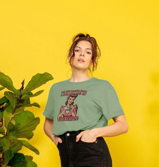 Woman stands against a bright yellow background, wearing a green T-shirt with a retro-style print. She exudes confidence, standing beside a leafy plant.