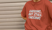 A person wearing a red offensive T-shirt with the playful phrase 