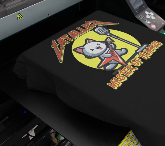 black t-shirt with a graphic of a cat playing a guitar and the slogan catallica master of humans
