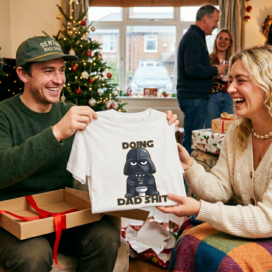 a woman giving a man the gift of a 'dad shit' t-shirt