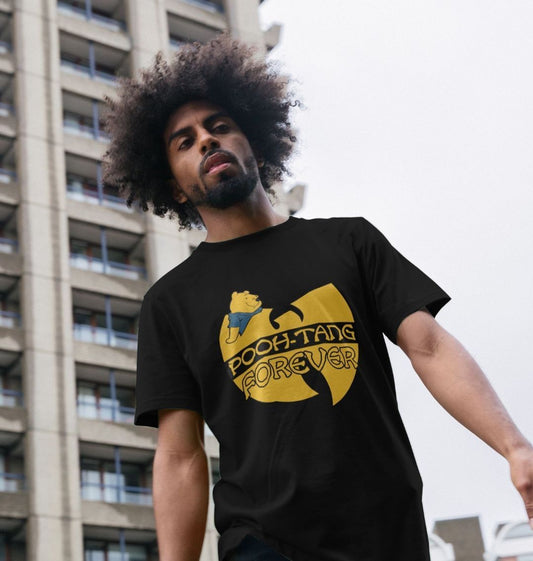 Man with a large afro stands in front of a tall building, wearing a black T-shirt with a playful "Pooh-Tang Forever" design, blending humour and street style.
