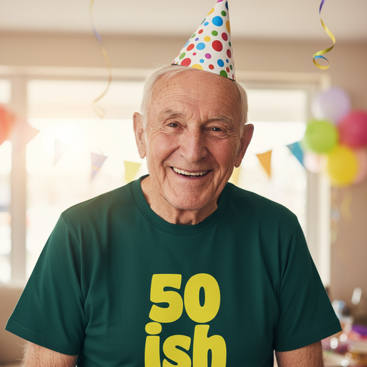 man wearing a party hat and a green slogan t-shirt with the text '50 ish'