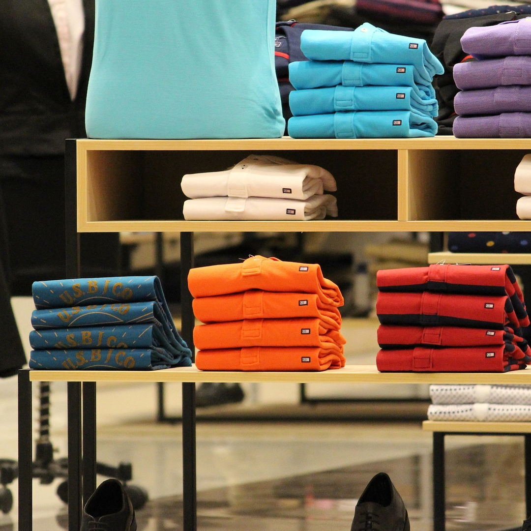an image of shelves with folded t-shirts on