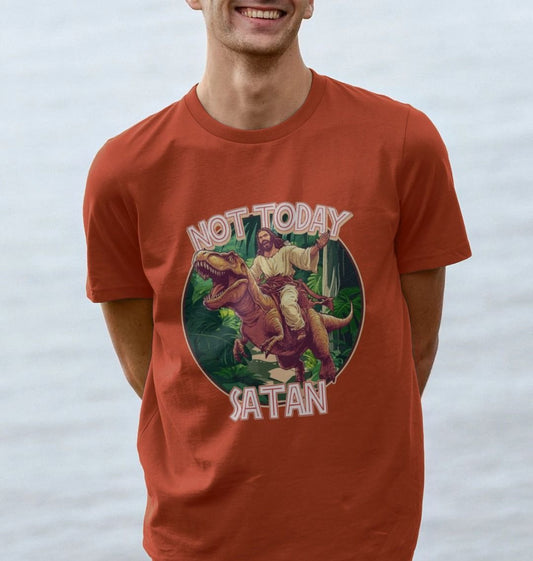 man wearing red graphic t-shirt featuring jesus riding a t-rex and the words not today satan