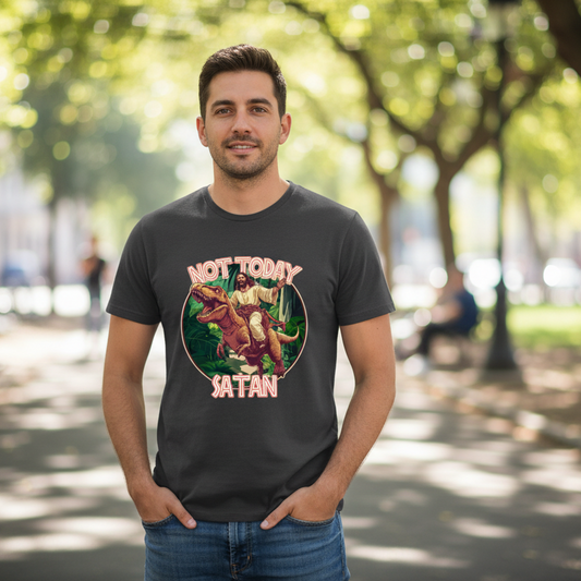 Man wearing a grey funny t-shirt with the graphic of jesus riding on the back of a t-rex and the slogan 'not today satan'