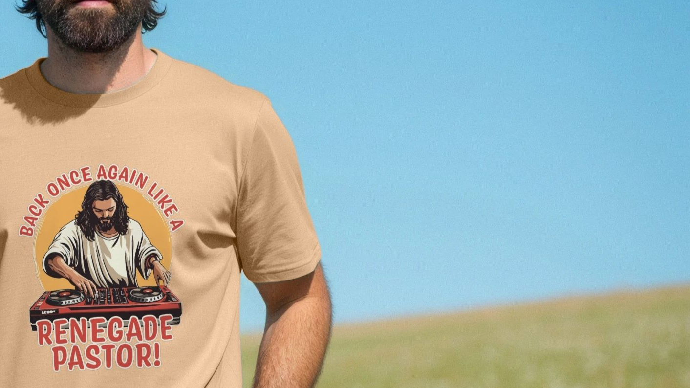 A man wearing a beige fun T-shirt with a graphic of a DJ resembling a biblical figure, text: "Back once again like a renegade pastor!" Sunny outdoor setting.