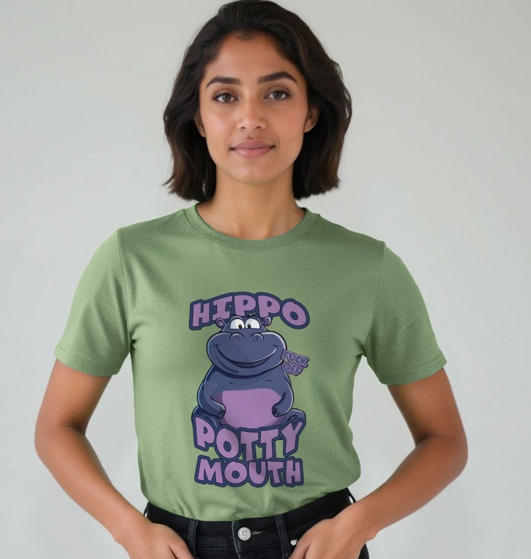 Woman in a green T-shirt with a cartoon hippo and text "Hippo Potty Mouth". She stands against a plain backdrop, conveying a playful mood.