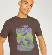 A man wearing a brown t-shirt featuring a cartoon character dressed in a green suit and purple gloves. The text reads: 