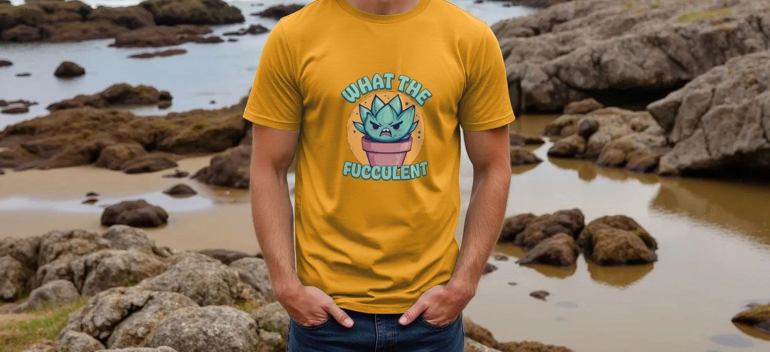 Man wearing a yellow Gardening T-shirt with a cartoon succulent and the words "What the Fucculent." Stony beach background adds a casual, humorous vibe.