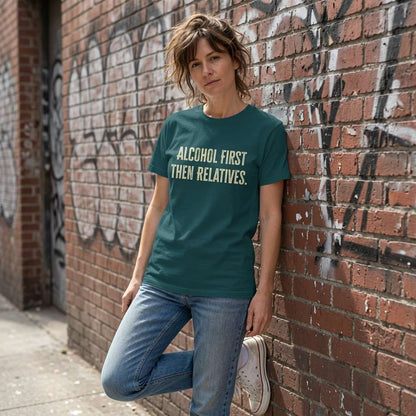 Woman in green Alcohol First Then Relatives t-shirt against graffiti wall, funny christmas pub quote tee