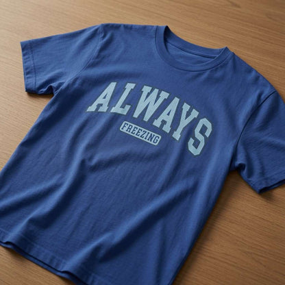Blue Always Freezing slogan t-shirt on wooden table, funny witty mum weather quote tee