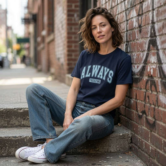 Woman in navy Always Freezing t-shirt sat on city steps, fun witty weather quote tee for mums