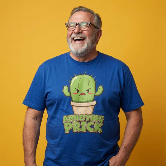 Man laughing with one hand in his pocket while wearing a blue Annoying Prick t-shirt featuring an angry cartoon cactus, witty mens cheeky cactus graphic design full of pure attitude that every cheeky lad will claim