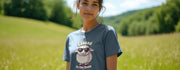 Young woman in a meadow wearing a gray funny Animal T-shirt with a cartoon sheep in sunglasses and the text 
