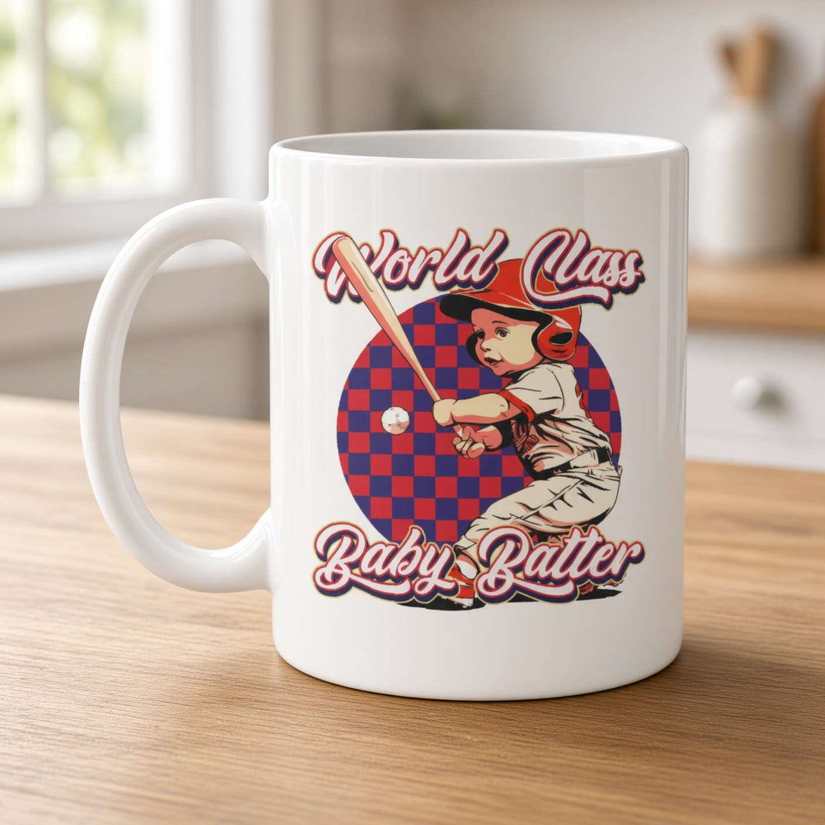 A white mug on a wooden counter features a vintage-style illustration of a child in a red helmet swinging a bat, with “World Class Baby Batter” text. The scene feels playful and nostalgic.