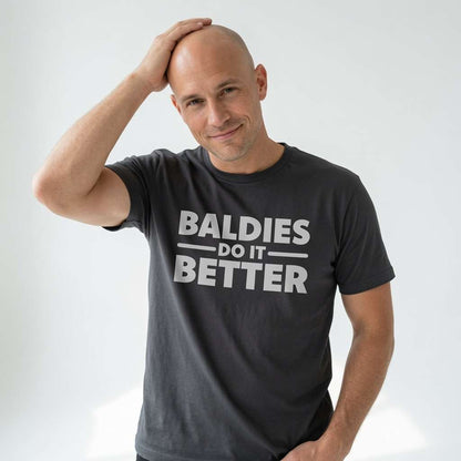 Man in dark grey Baldies Do It Better tee touching head, funny witty bald humour gift