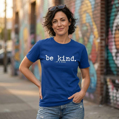 Woman in blue Be Kind of a Bitch t-shirt against graffiti, sarcastic relatable fun statement ladies shirt
