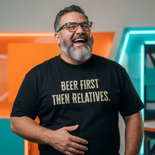 Man laughing with one hand on his stomach while wearing a black Beer First Then Relatives t-shirt, funny mens witty christmas day beer slogan design full of pure attitude