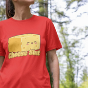 Person wearing a red funny graphic t-shirt with a kawaii cheese graphic and 'Cheese Slut' slogan, outdoors.