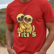 Man wearing a red funny kawaii T-shirt featuring two cartoon titi monkeys hugging with large, expressive eyes. Text reads 
