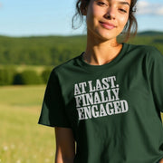 Smiling woman in a forest green Engaged T-shirt with 