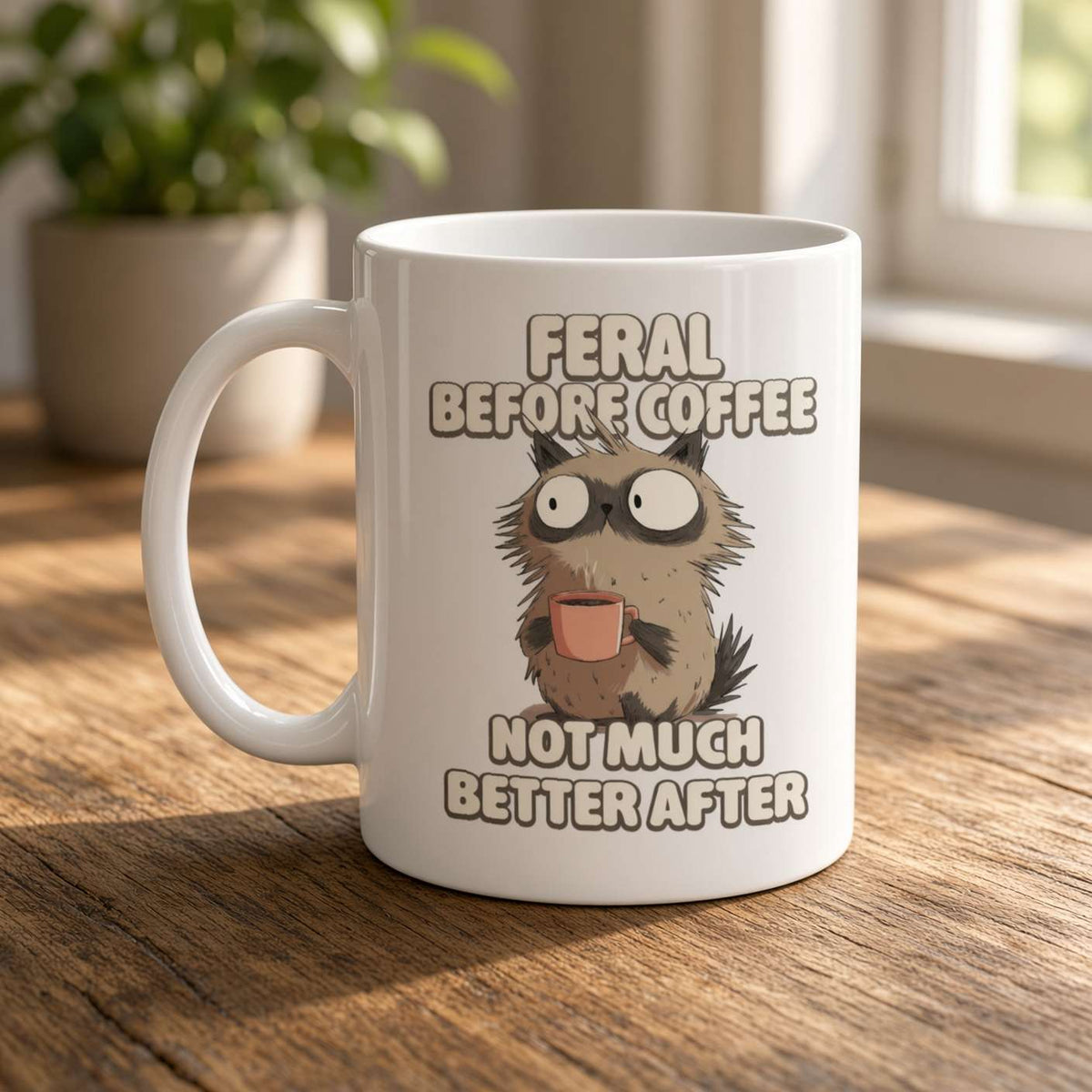 White mug featuring a wide-eyed, shaggy animal holding a tiny cup, with the joke “Feral before coffee, not much better after”—playful, sleepy humor.