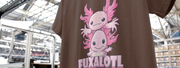 Brown Axolotl t-shirt featuring two cute, cartoon pink axolotls with playful expressions stacked atop one another, text 