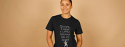 Smiling Woman wearing a black T-shirt with white text: 
