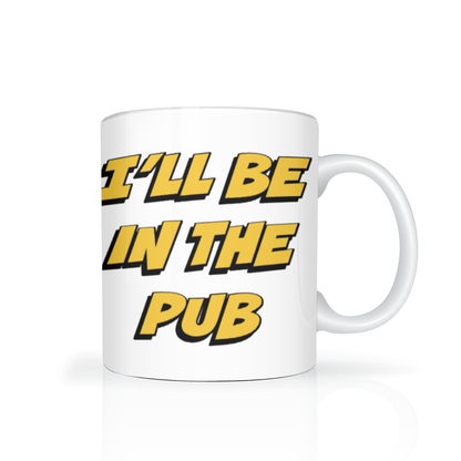 White ceramic mug with bold yellow, black-outlined text reading “I’LL BE IN THE PUB,” set against a plain white background; the playful message feels casual and humorous.