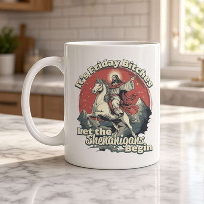 White ceramic mug on a marble kitchen counter, printed with a witch riding a unicorn and the playful phrase “Let the Friday Bitch Shenanigans Begin.”