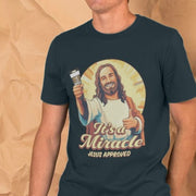 A man wears a funny offensive T-shirt featuring an illustrated Jesus figure giving a thumbs-up, holding a tube of glue, and surrounded by rays. The text reads 