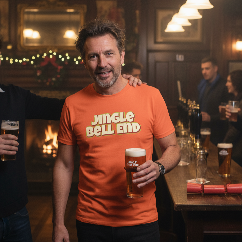 Man wearing an orange 'Jingle Bell End' rude Christmas shirt holding a beer in a pub setting.