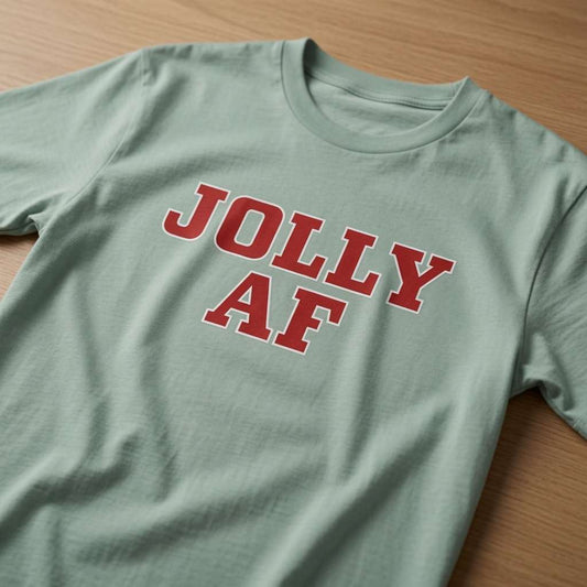 Aloe Jolly AF t-shirt laid flat on a wooden surface showing the bold red slogan, funny cheeky ladies Xmas slogan shirt that every no-nonsense lady will claim