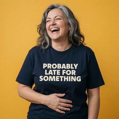 Woman laughing with one hand on her stomach while wearing a navy Probably Late For Something t-shirt, funny ladies cheeky relatable slogan shirt that every no-nonsense lady will claim