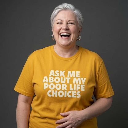 Woman laughing with one hand on her stomach while wearing a yellow Ask Me About My Poor Life Choices t-shirt, funny relatable ladies statement design full of pure attitude