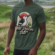 A man wearing a green funny graphic t-shirt with a cartoon woodpecker and 