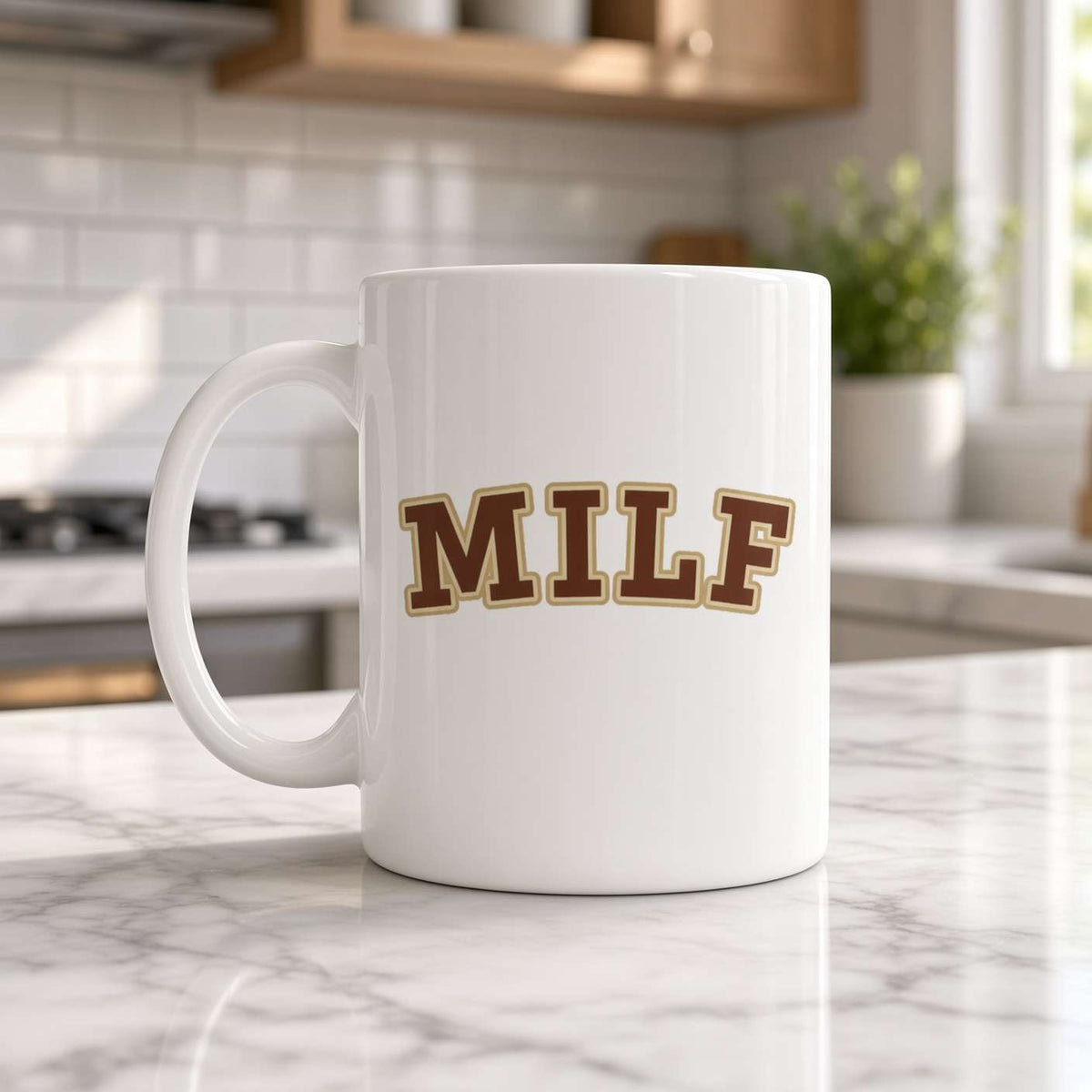 A white ceramic coffee mug with the word 'MILF' printed in brown varsity-style letters outlined in gold, sitting on a marble kitchen counter.